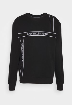 Schwarzer Sweatshirt mit langen Ärmeln, weißen vertikalen und horizontalen Streifen sowie dem Schriftzug "Calvin Klein Jeans" auf der Brust und Seite.