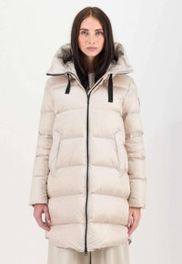 Piumino color beige chiaro con cappuccio, chiusura con zip e dettagli neri. Presenta un design trapuntato e tasche laterali, realizzato in un materiale lucido.