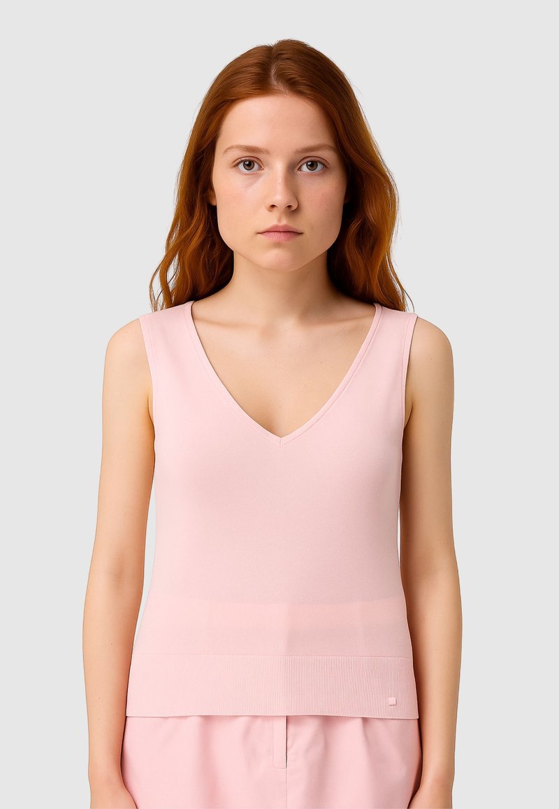 Top senza maniche rosa con scollatura a V, realizzato in tessuto morbido, con un orlo a coste e una silhouette aderente. Branding discreto visibile.