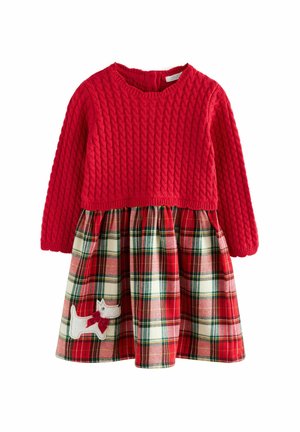 Rotes gestricktes Kleid mit einem karierten Rock in Rot, Grün und Creme. Es hat eine weiße Hundeausschnittapplikation mit einer roten Schleife auf der unteren linken Seite.