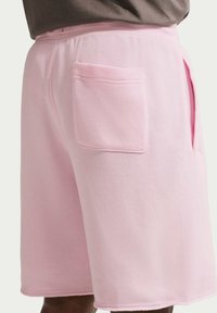 Vaaleanpunaiset puuvillashortsit, joissa on joustava vyötärönauha, sivutaskut ja takatasku, sileä pinta ja huolitellut reunat.