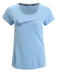 Camiseta deportiva azul claro con un cuello redondo, mangas cortas y textura de malla. Cuenta con un logo de Nike azul oscuro en la parte frontal.