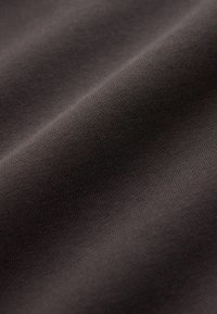 Tissu marron foncé avec une surface lisse et légèrement texturée, mettant en valeur un motif de tissage fin et une drapé flexible.