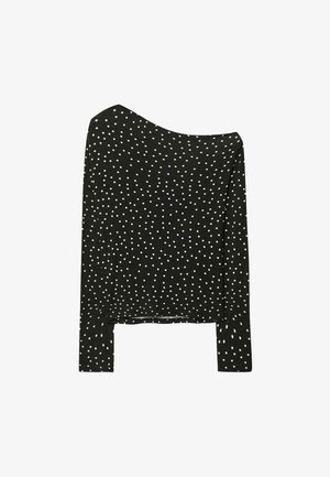 Schwarzes Langarmshirt mit schulterfreier Gestaltung, versehen mit weißen Punkten, aus weichem Material und im entspannten Schnitt.