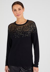 Pullover nero a maniche lunghe con scollatura rotonda, caratterizzato da un design di paillettes oro scintillanti che sfuma da denso a sparso sulla parte anteriore.