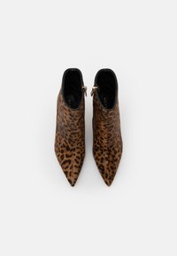 Botines hasta el tobillo con estampado de leopardo, punta afilada, detalles en negro y cremallera dorada en el lateral. Fabricados con un material suave y texturizado.