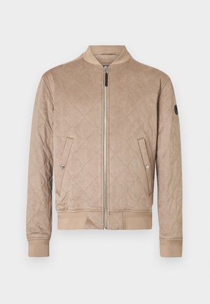 Beżowa pikowana kurtka bomberka z zamkiem z przodu, ściągaczami na mankietach i u dołu. Boczne kieszenie z zapięciem na zatrzask i teksturowane wykończenie materiału.