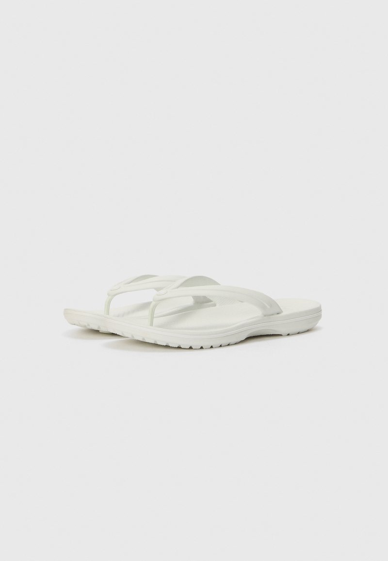 Weißer Flip-Flop mit strukturiertem Fußbett, doppelten Riemen und einer flexiblen Gummisohle mit einem gemusterten Profil für besseren Halt.