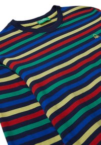 Maglietta a girocollo piegata con strisce orizzontali rosse, verdi, gialle, blu e navy e un piccolo logo giallo ricamato sul petto.