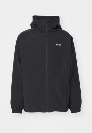 Chaqueta ligera negra con cremallera frontal, capucha y puños elásticos. Presenta el logotipo "huf" en el lado izquierdo del pecho. Textura suave, diseño minimalista.