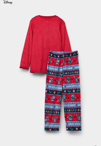 Czerwony długi rękaw z okrągłym dekoltem w połączeniu z czerwono-niebieskimi świątecznymi spodniami do piżamy ozdobionymi motywami Stitcha i wzorami świątecznymi. Miękka faktura tkaniny.