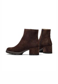 Stivaletti in suede marrone con tacco a blocco, cerniera laterale e superficie texturizzata. La suola presenta un motivo di grip per una migliore aderenza.