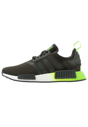 Zwarte Adidas NMD-sneaker met drie strepen, witte middenzool en neon groene hielaccenten, gezien in zijprofiel op een witte achtergrond.