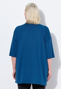 T-shirt blu oversize realizzato in tessuto morbido, con maniche corte e scollatura arrotondata. Tessuto liscio con una vestibilità comoda.