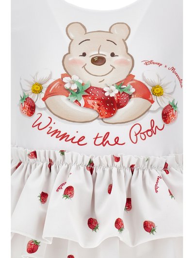 Ο Γουίνι το Αρκουδάκι γελάει κρατώντας φράουλες και λευκά λουλούδια, με σκορπισμένες φράουλες και το κείμενο «Γουίνι το Αρκουδάκι» σε λευκό ύφασμα.