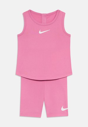 Set sportiv roz format dintr-un top fără mâneci cu gât rotund și pantaloni scurți asortați. Ambele au logo-uri Nike albe. Material neted și elastic.