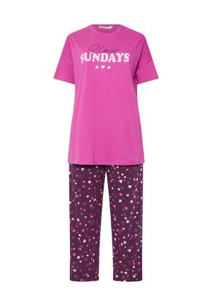 T-shirt rosa con testo "Slow Sundays", abbinato a pantaloni pigiama viola con cuori e stelle in rosa, bianco e grigio. Materiale in cotone.