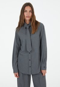 Grau gestreifte Bluse aus leichtem Stoff, mit spitzem Kragen, Knopfverschluss, langen Ärmeln und einer gebundenen Halsdetails.