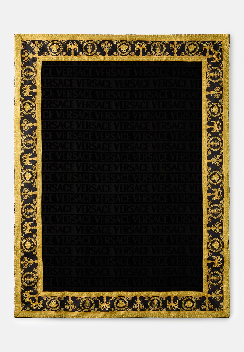 Black scarf featuring a gold baroque pattern and a repeating "VERSACE" logo throughout the center. Finished with a gold-fringed border.