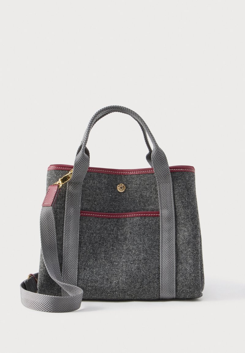 Pelēka soma ar maroon apdari, priekšējo kabatu, īsām rokturiem un regulējamu plecu siksnu ar zeltainiem aksesuāriem.