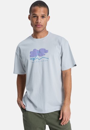 Jasnoszary t-shirt z krótkim rękawem, z fioletowym nadrukiem kwiatów i gór, wykonany z bawełny, o luźnym kroju i okrągłym dekolcie.