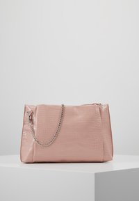 Růžová lakovaná kožená kabelka s texturou krokodýlí kůže, vybavená stříbrným řetízkovým popruhem a zipovým uzávěrem. Obdélníkový tvar s lesklým povrchem.