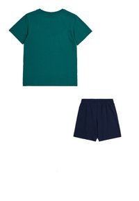 Camiseta de algodón color verde azulado con cuello redondo y mangas cortas, combinada con pantalones cortos de algodón azul marino que tienen una cinturilla elástica.