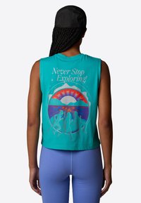 Teal cropped tanktop met een grafisch ontwerp van hardlopers, bergen en een zon, met de tekst "Never Stop Exploring!" in het wit.