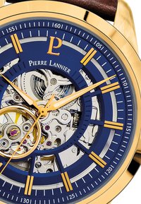 Automatic watch with a blue dial, gold accents, and transparent case revealing inner mechanics. Features a brown leather strap.