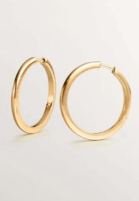 Pendientes de aro de oro con un acabado suave y pulido. Forma circular con cierre de bisagra, que presenta un diseño sin costuras.