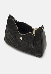 Bolso de mano de cuero negro con patrones en relieve, cremallera en tono dorado y un pequeño acento de marca. La vista en ángulo muestra el forro interior.