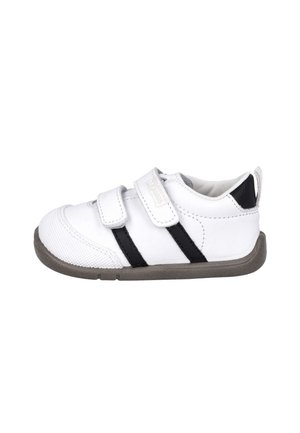 Zapatilla blanca para niño pequeño con dos tiras de velcro, talón negro y rayas laterales, suela gris y puntera texturizada.