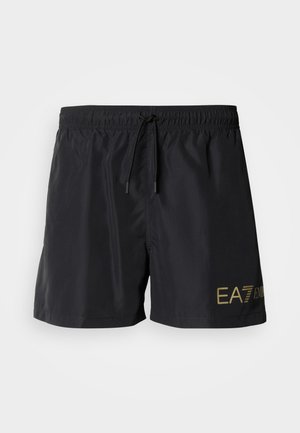Black swim shorts made of lightweight material, featuring an elastic waistband with drawstring and a gold logo on the side.