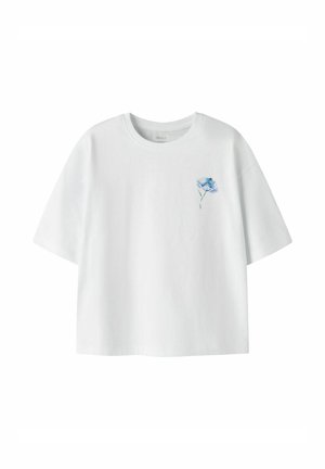 Biała koszulka z krótkim rękawem i okrągłym dekoltem, z małym niebieskim kwiatowym wzorem na lewej stronie klatki piersiowej.