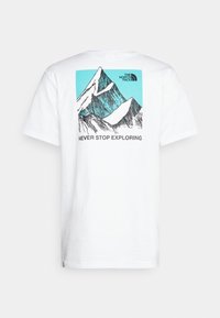 Camiseta blanca de algodón con un gráfico de montaña en verde azulado y negro, con el texto "NUNCA DEJES DE EXPLORAR" debajo del diseño.
