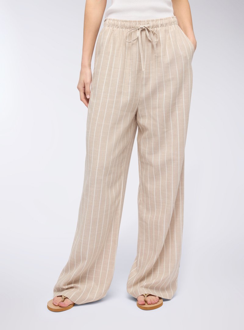 Pantaloni in lino beige chiaro con strisce verticali bianche, vita elastica, cordoncino regolabile e tasche laterali. Design a gamba ampia.