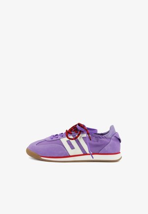 Sneaker viola in pelle scamosciata e tessuto con strisce laterali geometriche bianche, lacci rossi e neri e suola in gomma con una striscia rossa e bianca sulla suola intermedia.