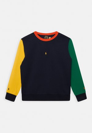 Sweat-shirt bleu marine avec manche gauche jaune, manche droite verte, encolure orange, petit logo jaune centré sur la poitrine et poignets noirs.