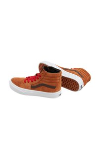 Baskets montantes en daim marron avec des lacets rouges, semelles en caoutchouc blanc et rayures d'accent marron. Présente une surface texturée et un col rembourré.