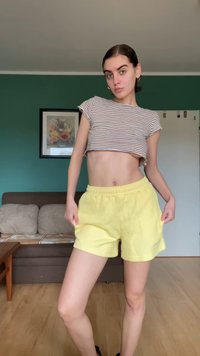 Striped crop top in white and brown, paired with yellow shorts. The shorts have an elastic waistband and a soft texture. Details include pockets.
