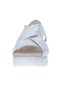 Sandalia metálica azul claro con tiras entrecruzadas, punta abierta y plantilla acolchada en beige; suela de goma blanca.