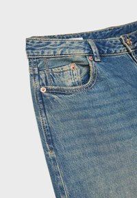 Džínsy v svetlom modrom prevedení, s klasickým strihom, prednými vreckami a medenými nitmi. Mäkka textúra s vyblednutým, opotrebovaným efektom.