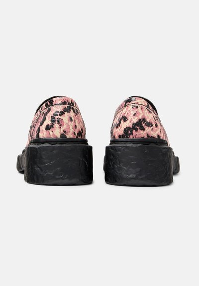 Pink and black patterned slip-on shoes with a thick black sole, featuring a textured finish and rounded toe design.