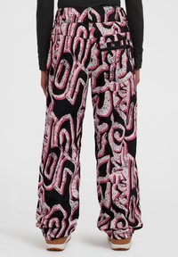 Losse broeken van zwarte stof met een gedurfde, abstracte roze en witte print. Inclusief ritszakken aan de zijkant.