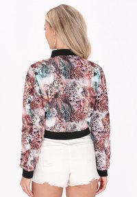 Bunte Bomberjacke mit gemischten Tiermotiven, schwarzen gerippten Bündchen und einem cropped Design. Glattes Material mit glänzendem Finish.