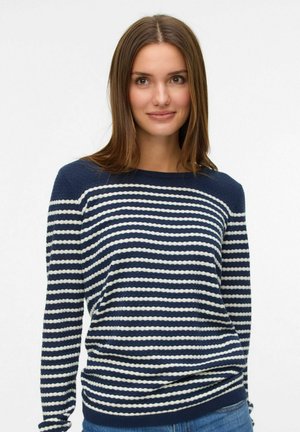 Pull en tricot à rayures bleu marine et blanc, avec une coupe décontractée, un col rond et un ourlet côtelé. Le tissu texturé apporte de la profondeur au design.