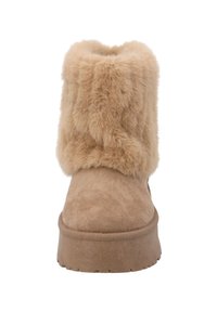 Beige Wildleder-Winterstiefel mit dicker Gummisohle und plüschigem, flauschigem Fellbund, der den Knöchel und den oberen Fußbereich bedeckt.
