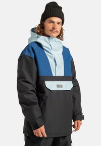 Męska kurtka anorak w kolorze jasnoniebieskim i granatowym, z czarną dolną częścią, dużą przednią kieszenią i regulowanym kapturem.