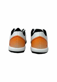 Scarpe da ginnastica bianche con un motivo a pois arancione sfumato sul tallone, accenti neri e una suola texturizzata. La vista posteriore mostra un design elegante.