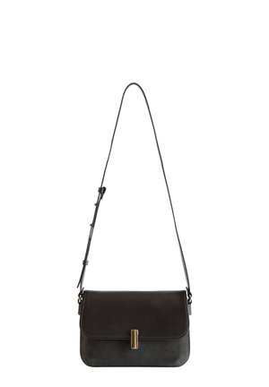 Schwarze Leder-Crossbody-Tasche mit verstellbarem Schultergurt und goldenen vertikalen Riegelverschluss auf der Frontklappe.